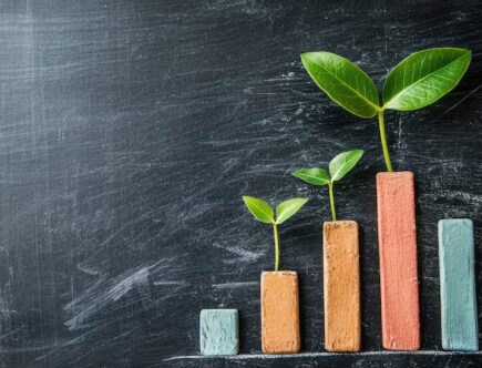 Staplar i olika färger med gröna blad som växer