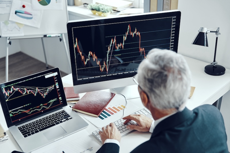 Man vid dator som handlar med aktier